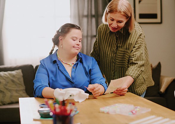 A carer holding a participant's hands gently in support