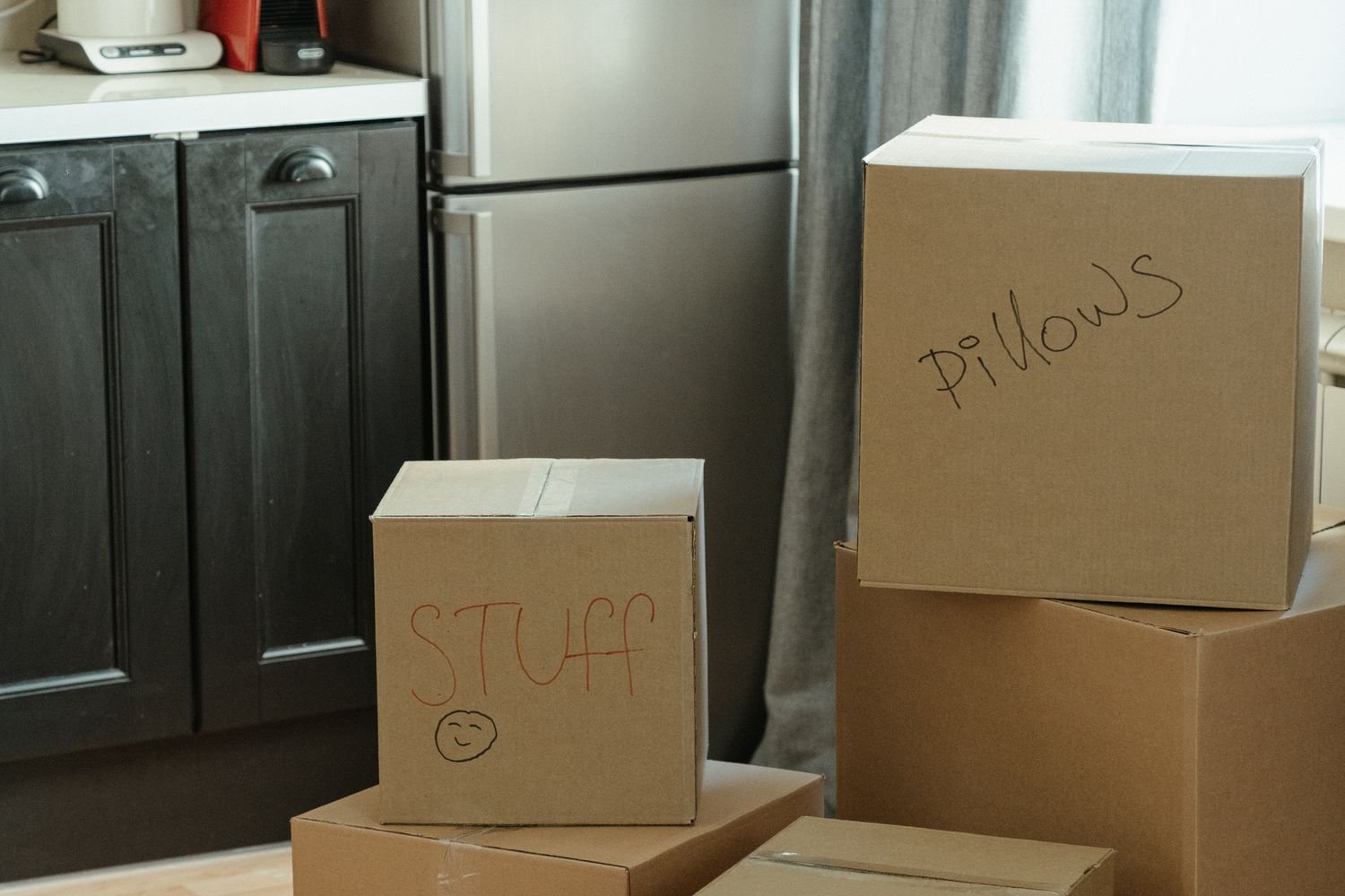 Packed moving boxes in a kitchen, a reminder that NDIS medium term accommodation is for the wait before moving home